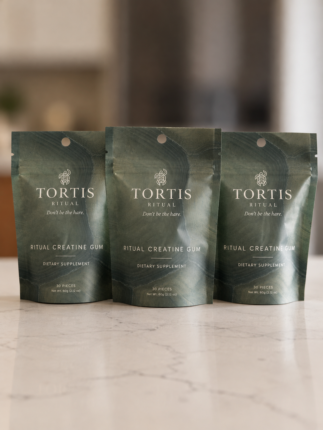 Three TORTIS Ritual creatine gum pouches standing on a counter
